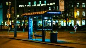 Valgustatud bussipeatus öises linnas loob müstilise ja rahuliku atmosfääri.