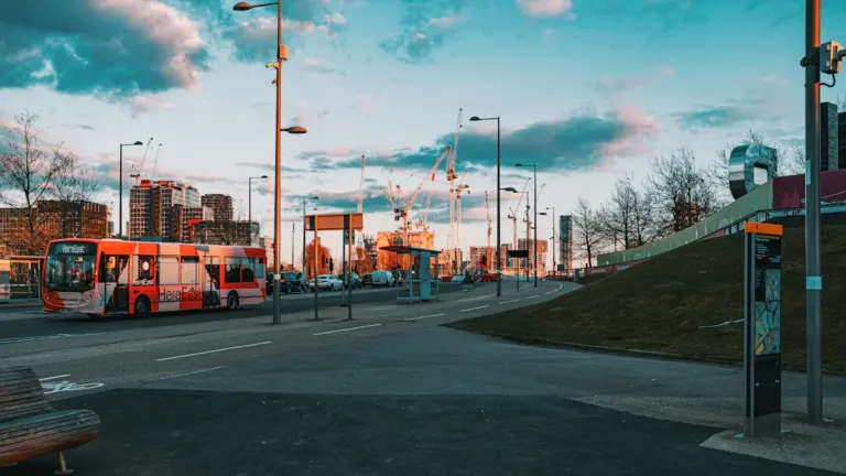 Kaasaegne linnatänav bussiga, mis sümboliseerib avaliku transpordi tähtsust ja linna infrastruktuuri arengut.