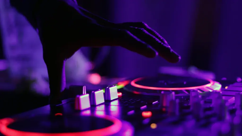 DJ kätt asetamas valgusküllasele pultile ööklubi atmosfääris Pärnu diskoõhtul.
