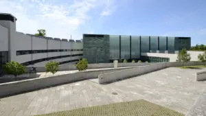 Eesti Rahva Muuseumi kaasaegne hoone koos laia kaldtee ja sillutatud väljakuga päikeselisel päeval.