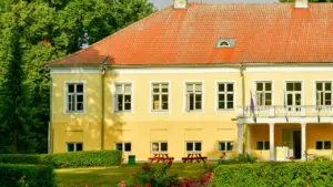 Tõstamaa mõis suvisel ajal koos kauni rohelise aia ja õitsvate roosidega.